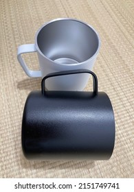 Black and white metal mug cups on Tatami mat. Colored Stainless steel