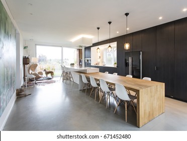 Black & White Minimalistic Kitchen With Wood Details. Concrete Floor, Composite White Worktops.