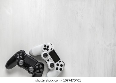 black and white modern gamepad on white wooden background - Powered by Shutterstock