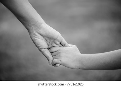 Black And White Of Mother Holding A Hand Of His Son.  Love , Famiy And Mother Day Concept.