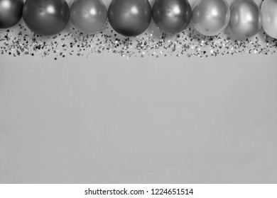 Black and white. Multicolor party or birthday background on blue with a frame of colorful party balloons, streamers, confetti and candy around central copy space - Shutterstock ID 1224651514