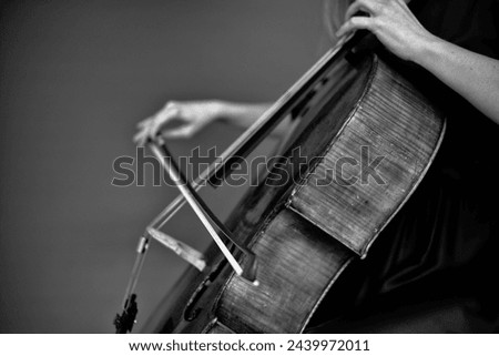 Black and white. Musician playing cello. Cellist or Cello player performing with monochrome  background, beautiful filmic, artistic  beautiful woman playing the cello