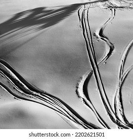 Black and white off-piste slope with track from ski and snowboard at night. View from above. High contrast.