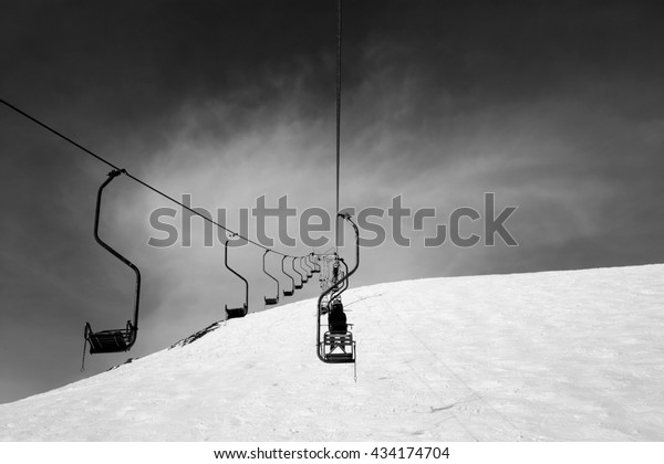 Black and white old chair-lift in\
ski resort. Caucasus Mountains, Elbrus region, mount\
Cheget.