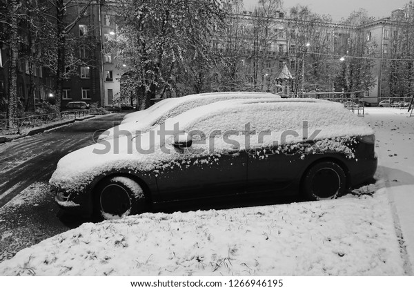 black and white parked cars covered with snow\
after a blizzard