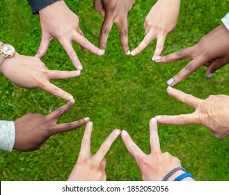 Black and white people forming nine pointed star with their fingers.