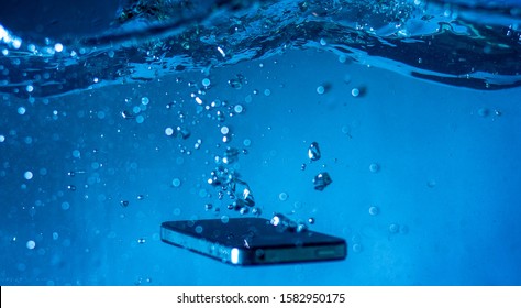 Black And White Phone Dropped Into The Water. Phone In Water.phone In Water Bubbles.phone Sinks In Water