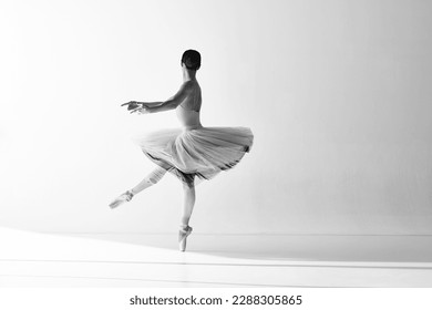 Black and white photo. Aesthetic of ballet. Professional ballerina wearing pointe shoes dancing on fingertips with hands over white background. The art, artist, movement, action and motion concept - Powered by Shutterstock