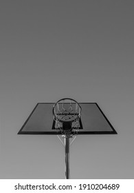 a black and white photo of a basketball hoop in front of clear skies