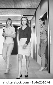 Black And White Photo Of Business People Coming Out Of Elevator In Office