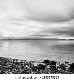 A black and white photo of a calm ocean horizon in the morning