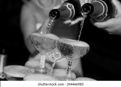 Black And White Photo Of Champagne Poured Into A Glass During Wedding