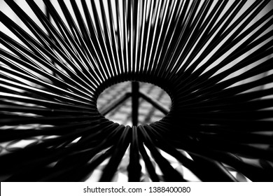 Black and White photo of the circular base of a chair creating an abstract pattern around it.
