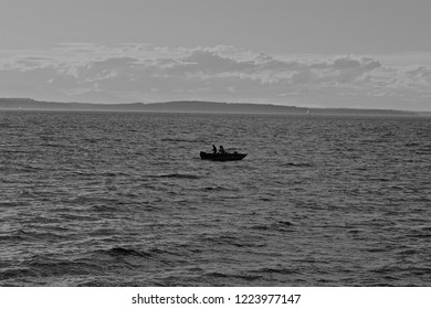 Black And White Photo Of A Couple Fishing In A Boat On The Ocean Near The Washington Coast. 