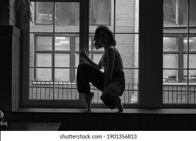 Black And White Photo Of Dancer In The Window Frame In An Old Building. Young, Elegant, Graceful Woman Ballet Dancer