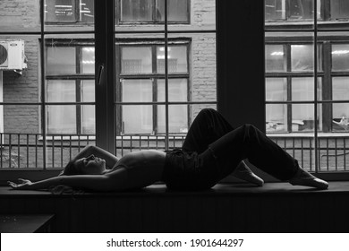 Black And White Photo Of Dancer In The Window Frame In An Old Building. Young, Elegant, Graceful Woman Ballet Dancer