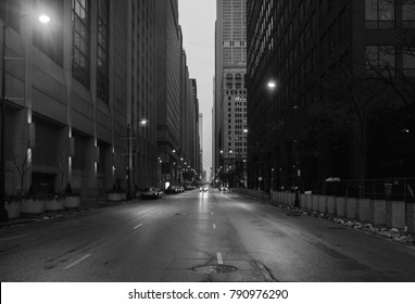 A Black And White Photo Of Downtown Chicago. The Shot Is Taken From The Middle Of The Street.