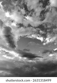 Black and white photo of dramatic clouds in the sky. Minimalist atmospheric background, moody weather scene, and natural cloud texture. Perfect for abstract or emotional visuals.