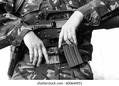 Black & White Photo Of Female Soldier On Guard.Miliary Woman Hold Automatic Assault Rifle.Armed & Dangerous Soldier Girl Guarding Peace & Law.National Guard Female Warrior Protecting Her Country