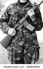 Black & White Photo Of Female Soldier On Guard.Miliary Woman Hold Automatic Assault Rifle.Armed & Dangerous Soldier Girl Guarding Peace & Law.National Guard Female Warrior Protecting Her Country