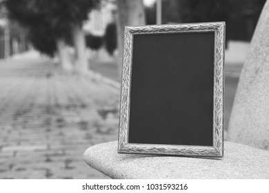 Black And White Photo Frame On A Park Bench. Mock Up.