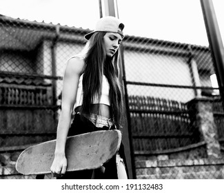 Black And White Photo Of A Girl With Skateboard Against The Sun