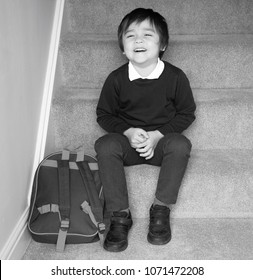 Black And White Photo Of Happy School Boy With Backpack Sitting On Stairs With A Big Smiling Face, Cute Kid Boy Getting Dressed And Get Ready For School, Back To School Concept