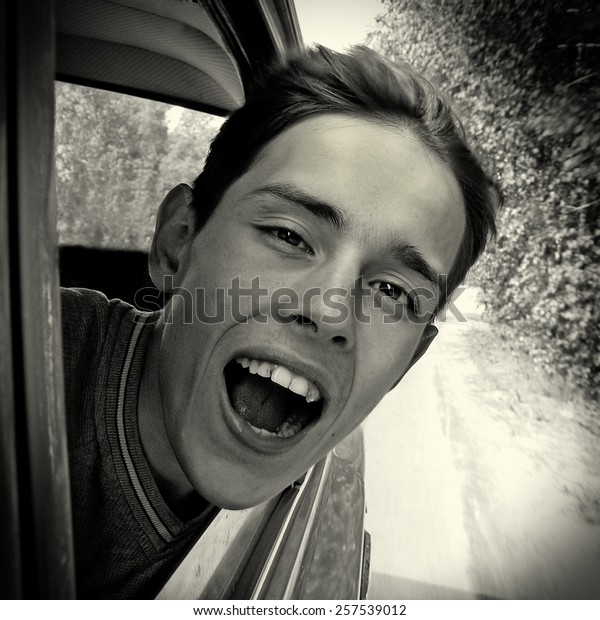 Black\
and White Photo of the Happy Teenager in the\
Car