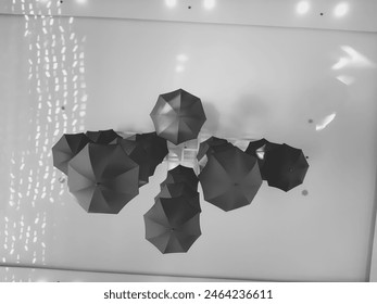 Black and white photo of hotel decoration consisting of hanging umbrellas - Powered by Shutterstock