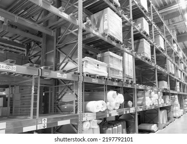 Black and white photo of the interior aisle of a warehouse with goods and boxes - Powered by Shutterstock