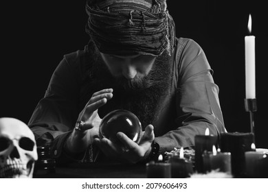 Black And White Photo Of Male Fortune Teller At Table