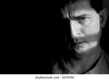 Black And White Photo Of A Man With A Furrowed Brow And A Doubtful Look On His Face.