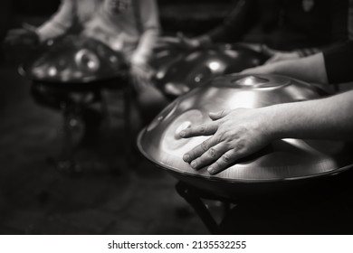 Black And White Photo Of A Musician's Hand Playing The Handpan With Other People. Handpan Is A Term For A Group Of Musical Instruments That Are Classified As A Subset Of The Steelpan. 