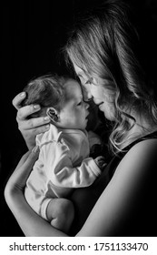 Black And White Photo Of Newborn Baby On An Isolated Black Background On His Mother. Healthcare And Medical Love Lifestyle Mother.