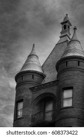 A Black And White Photo Of An Old Brick Building With Two Round Spires In Downtown Burlington, Vermont.