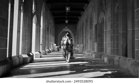 Black and white photo of a person walking through a long, arched corridor, capturing the timeless elegance and serene atmosphere of the architecture. Perfect for travel, architecture, and decor use.Bl - Powered by Shutterstock