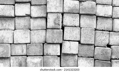 Black And White Photo Of A Pile Of Paving Blocks, A Composition Of Building Materials Made From A Mixture Of Portland Cement, Water And Aggregate With Or Without Other Additives.