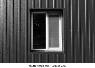 Black And White Photo Of Plastic Window Of Modern Barn House With Metallic Facade.