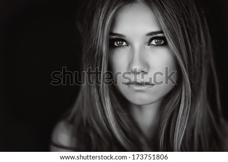 Black and white photo portrait of a girl who looks at the camera.