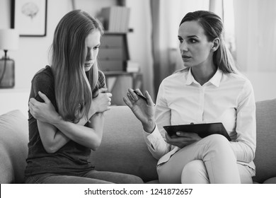 Black And White Photo Of Professional Pedagogue Relieving Stress Of Young Teenage Girl During Psychotherapy. Mental Health Concept.