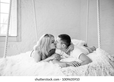 Black and white photo. A room in Scandinavian style. Suspended bed. Husband and wife are lying on the bed. Love, couple. Valentine's Day. - Powered by Shutterstock