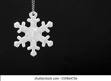 Black And White Photo Of Safety Reflector In The Form Of Snowflakes. Necessary Equipment To Pedestrians For Walks During Dark Conditions.