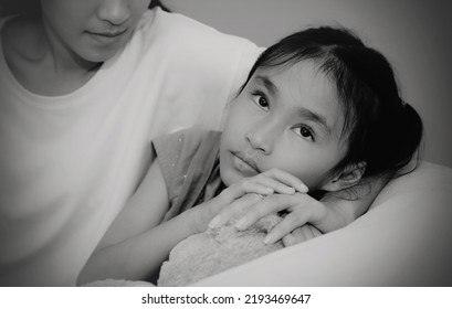 Black And White Photo Sensitive Asian Daughter With A Weak Heart And An Unhappy Face, Worried About Something, With A Caring Mother At Her Side To Help Relieve Stress.
