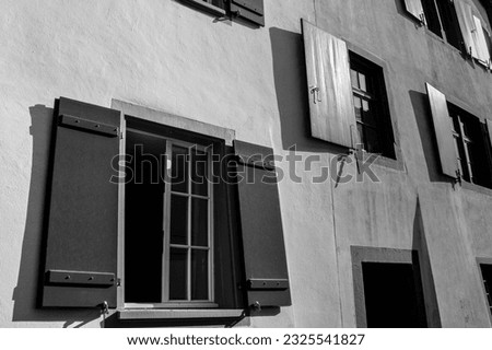 Black and white photo of several open windows in a building