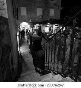 Black And White Photo Of Sexy Woman Walking Up The Stairs On Street At Night