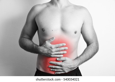 Black And White Photo Of Shirtless Caucasion Man Holding His Belly Because Of Stomach Ache With Red Dots Highlighting The Area