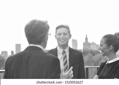 Black And White Photo Of Smiling Business Colleagues Discussing While Standing In City