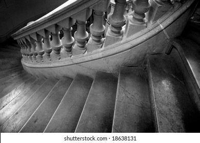 Black And White Photo Of Spiral Marble Staircase Leading Downward