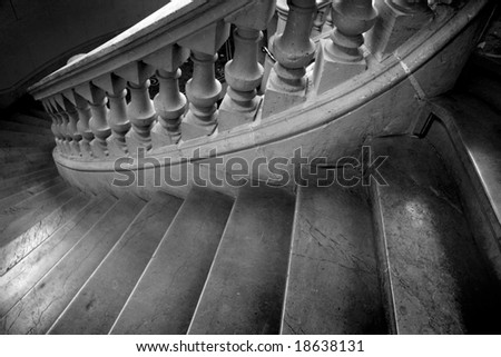 Black and white photo of spiral marble staircase leading downward