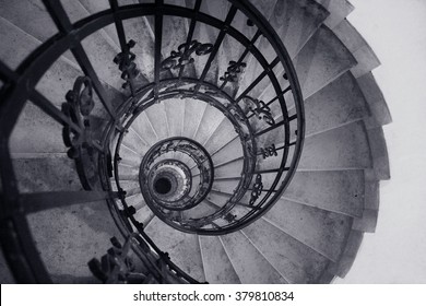 Black - White Photo Of A Spiral Staircase In An Old House